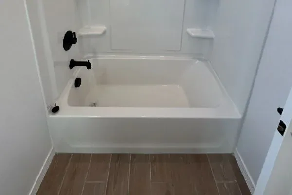 White acrylic alcove bathtub with matte-black tub and shower fixtures