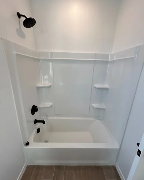White acrylic alcove tub-and-shower combo with oil-rubbed bronze fixtures