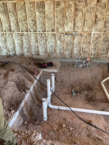 Drain stub-outs and trench at slab stage with framed walls and insulation